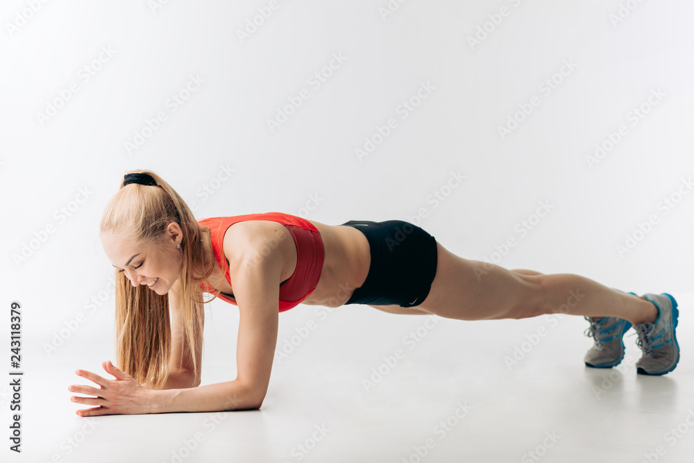 happy fit girl is doing some push-ups. side view full length shot. happy fit girl is doing some push-ups. side view full length shot.