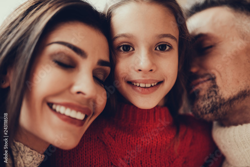 Cheerful girl hugging her parents with love