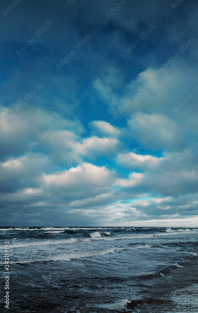 Blue winter seascape ocean view of the Baltic Sea with waves and dunes and blue color tones during winter Storm flood tide. German Baltic Sea coastline at Fischland-Darss-Zingst in Mecklenburg
