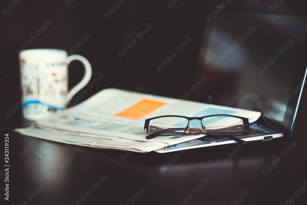 Laptop, newspaper and glasses on the table. Laptop, newspaper and glasses on the table.