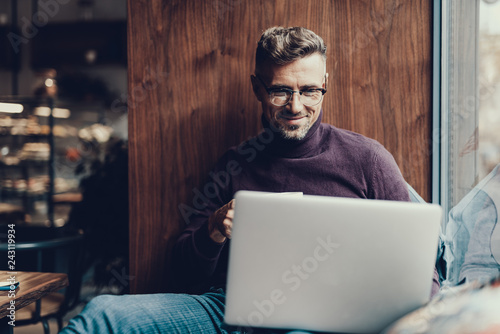 Man looking on netbook monitor and smiling photo