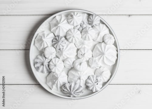 Meringues on white plate on white background