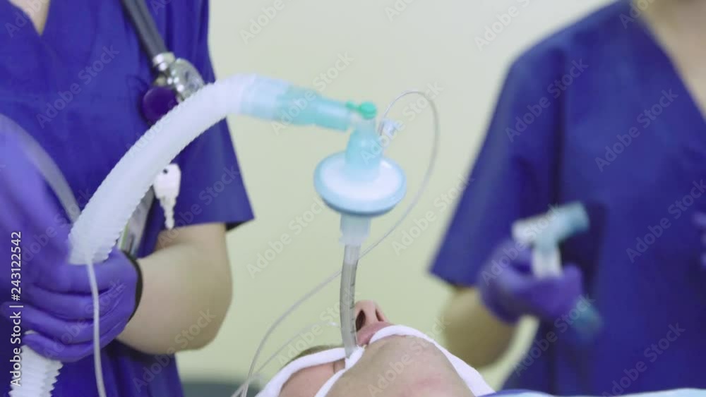Anesthesiologist connects breathing circuit with a patient's  endotracheal tube   during the surgery (4K, 25fps)