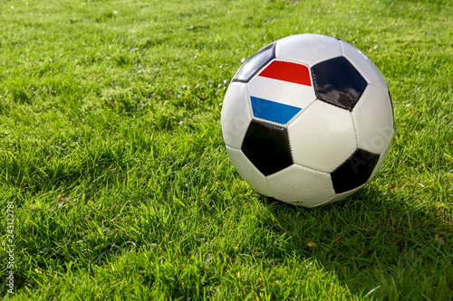 Football on a grass pitch with luxembourg Flag