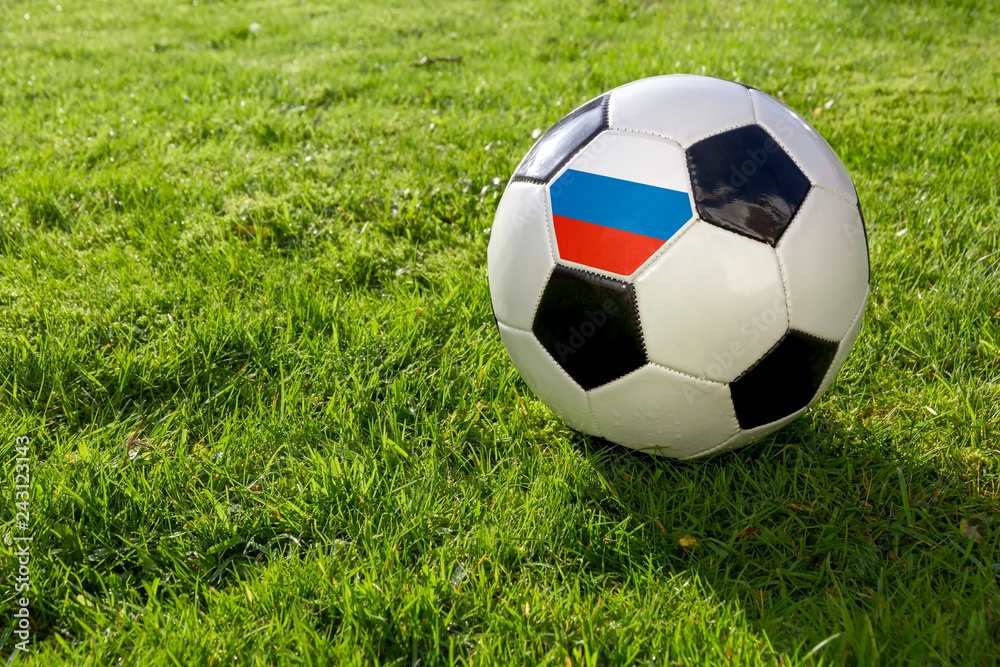 Fototapeta premium Football on a grass pitch with Russia Flag