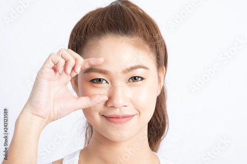 Beautiful Attractive Charming Asian woman smile and making frame for focus clear eye with healthy skin feeling so comfortable and happiness isolated on grey background,Beauty Concept