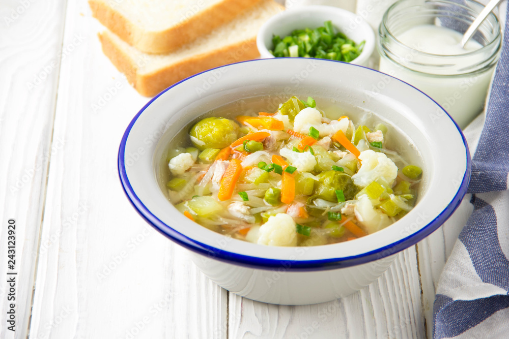 Vegetable soup with cauliflower, Brussels sprouts, white cabbage, carrots and green peas. Delicious healthy lunch, spring food