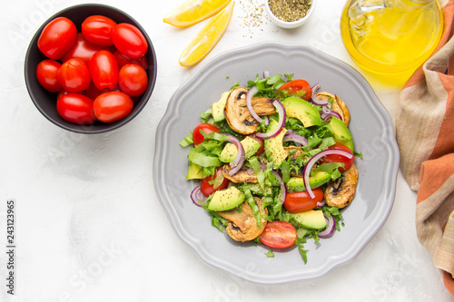 Fresh spring salad with mushrooms, cherry tomatoes, avocado and onions. Tasty vegetarian lunch, healthy food