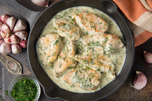 Tablou pe pânză Chicken fillet or Turkey breast in creamy sauce with dill and garlic, in cast iron black pan on dark background