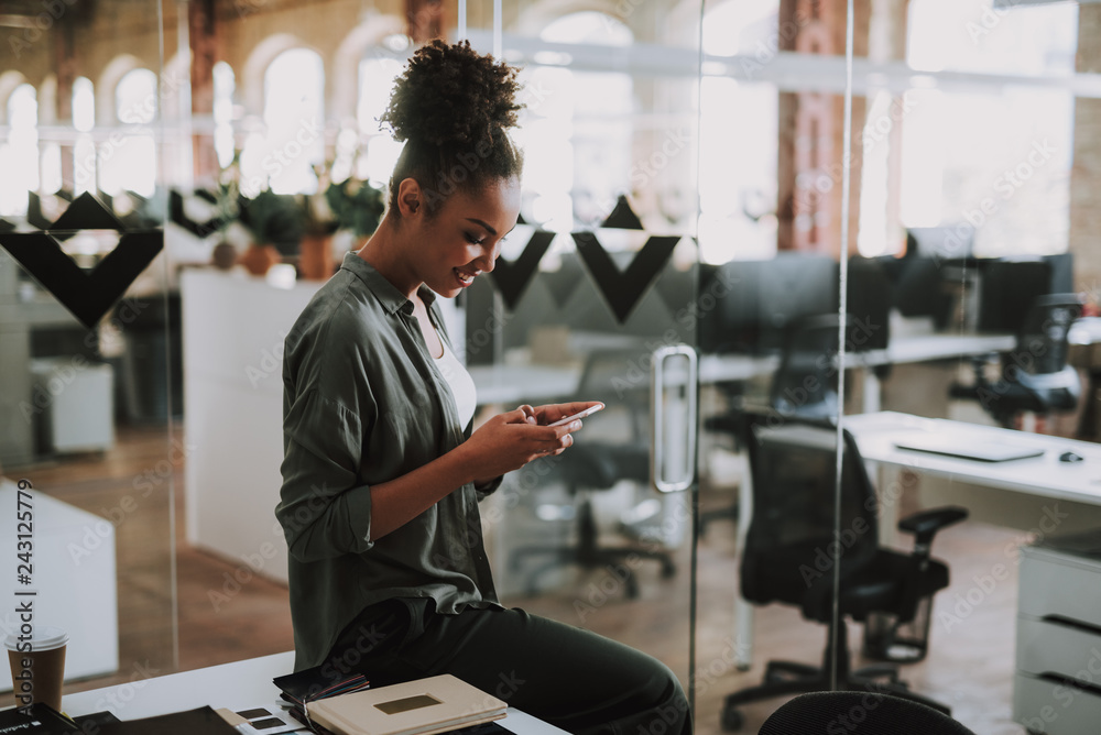 Beautiful afro american girl using cellphone at modern office Beautiful afro american girl using cellphone at modern office