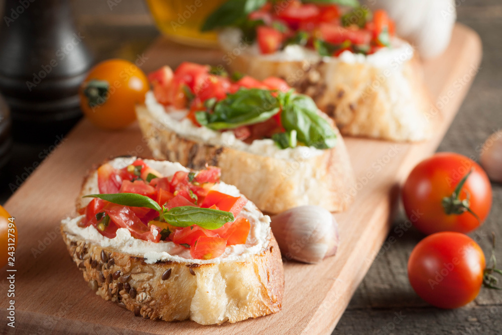 Italian tomato and cheese bruschetta. Tapas, antipasti with chopped vegetables, herbs and oil on grilled ciabatta and baguette bread.