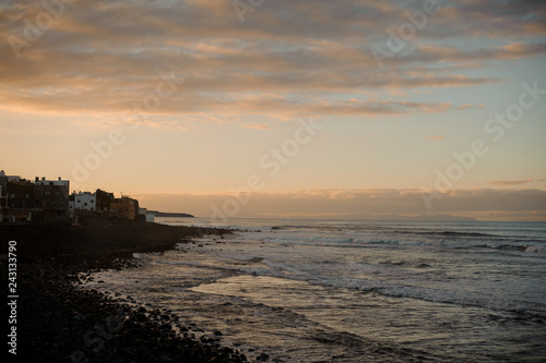 Twilight over ancient city and sea coast with waves under the sky