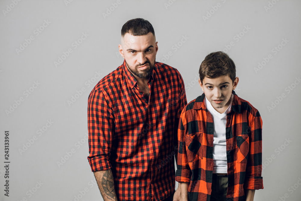 unhappy angry frustarted daddy and son looking at the camera. father and kid having problems with mother. emotion , feeling. fight. unhappy angry frustarted daddy and son looking at the camera. father and kid having problems with mother. emotion , feeling. fight.