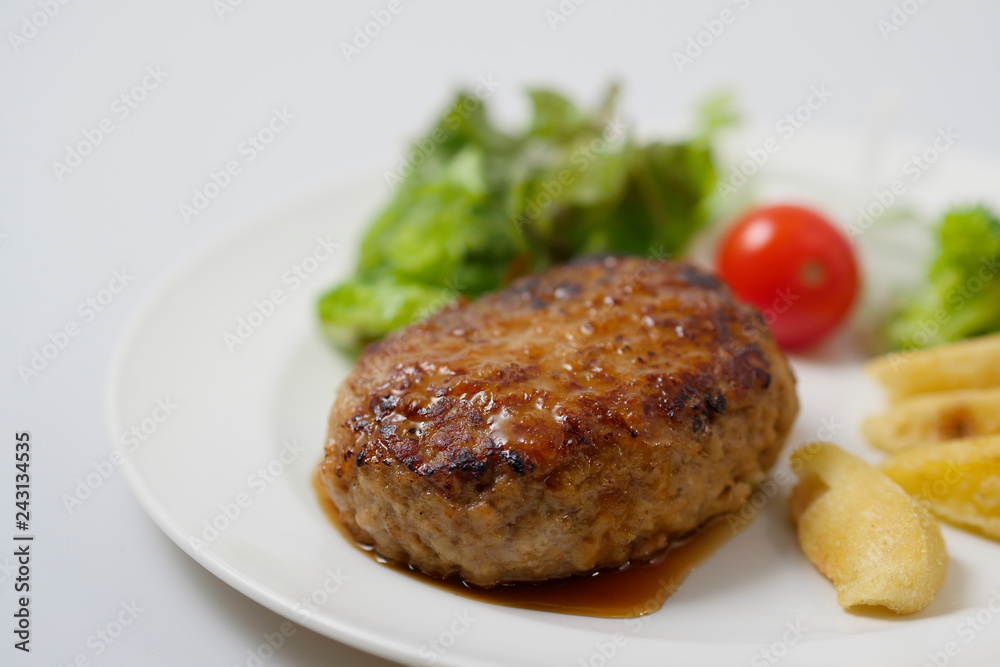 Hamburger steak and vegetables on white background
