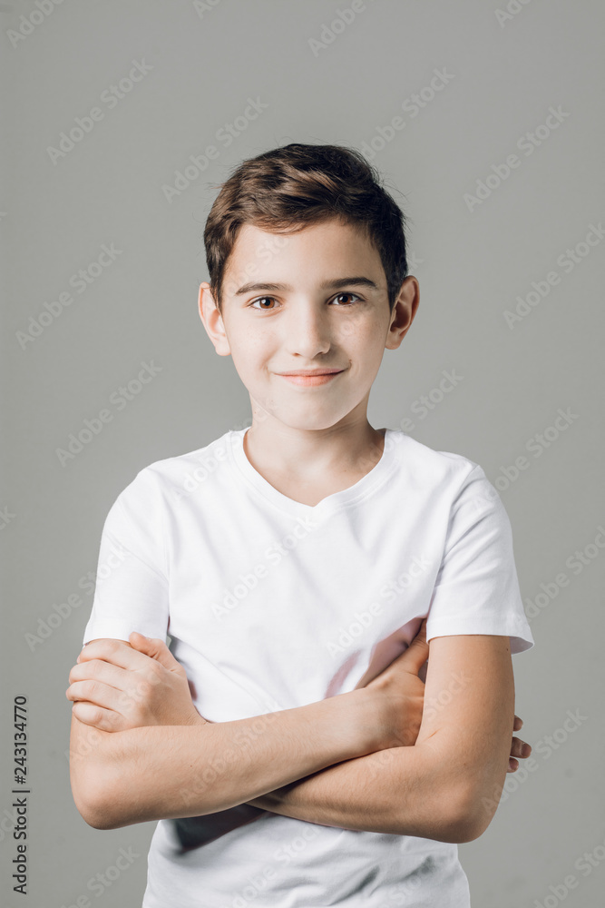 happy cheerful nice boy with crossed arms.close up shot, attarctive child in whilte T-shirt is posing to the camera happy cheerful nice boy with crossed arms.close up shot, attarctive child in whilte T-shirt is posing to the camera