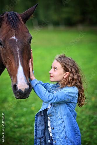 girl on the ranch is petting a horse © ambrozinio