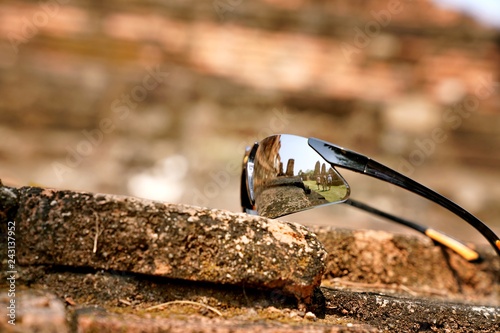 The reflection on a traveller's sunglasses at The Wat Mahathat, Ayutthaya, Thailand. This place also be one of ayutthaya historical park.