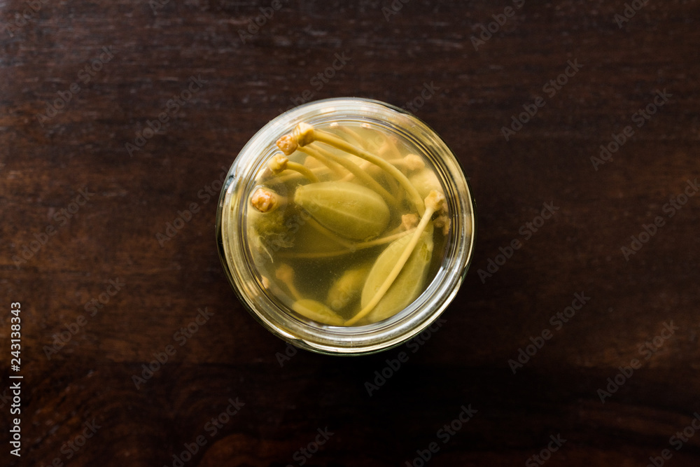 Jar of Capers in Water Pickled and Canned Ready to Eat in Glass Bowl. Jar of Capers in Water Pickled and Canned Ready to Eat in Glass Bowl.