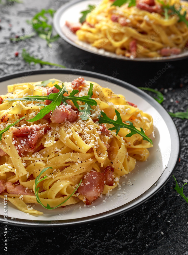 Classic Carbonara pasta, spaghetti with pancetta, bacon, egg, parmesan cheese and green arugula.