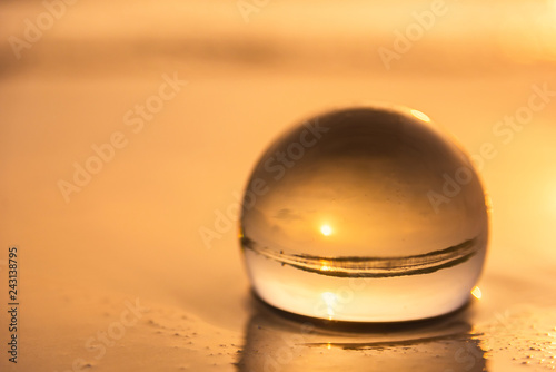 Crystal ball on the beach with sea waves at morning sunrise.Thailand.