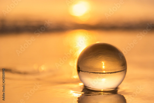 Crystal ball on the beach with sea waves at morning sunrise.Thailand. © bubbers