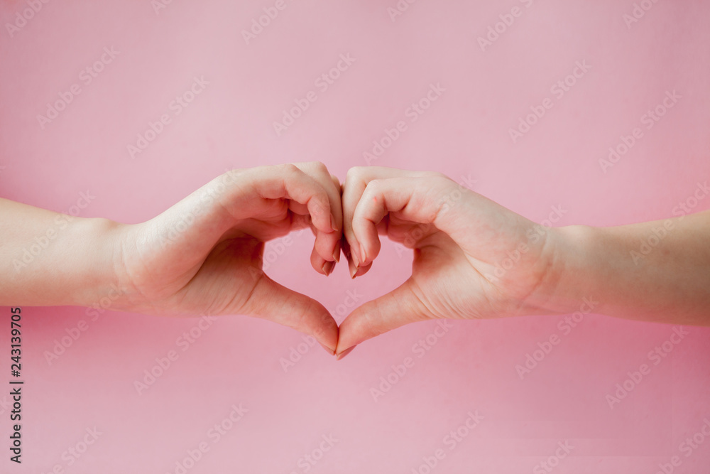 Beautiful young woman's hand with perfect manicure making heart on pink background. Flat lay style Beautiful young woman's hand with perfect manicure making heart on pink background. Flat lay style