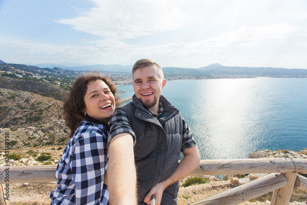 Travel, vacation and holiday concept - Lovely couple taking selfie near the sea