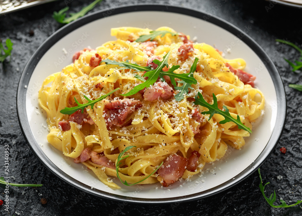 Classic Carbonara pasta, spaghetti with pancetta, bacon, egg, parmesan cheese and green arugula. Classic Carbonara pasta, spaghetti with pancetta, bacon, egg, parmesan cheese and green arugula.