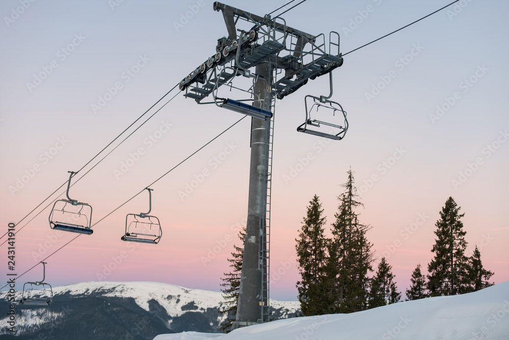 Ski lift chairs on winter resort against a amazing sky at sunset Ski lift chairs on winter resort against a amazing sky at sunset