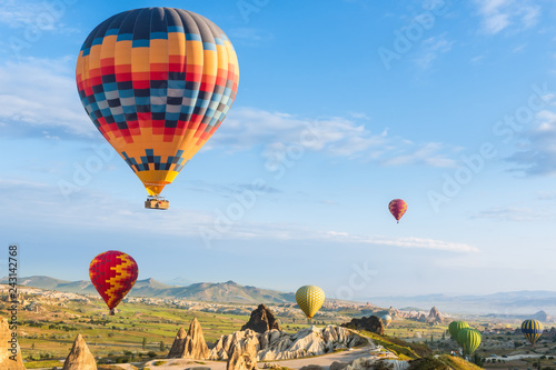 Hot air balloon flying over red poppies field Cappadocia region, Turkey