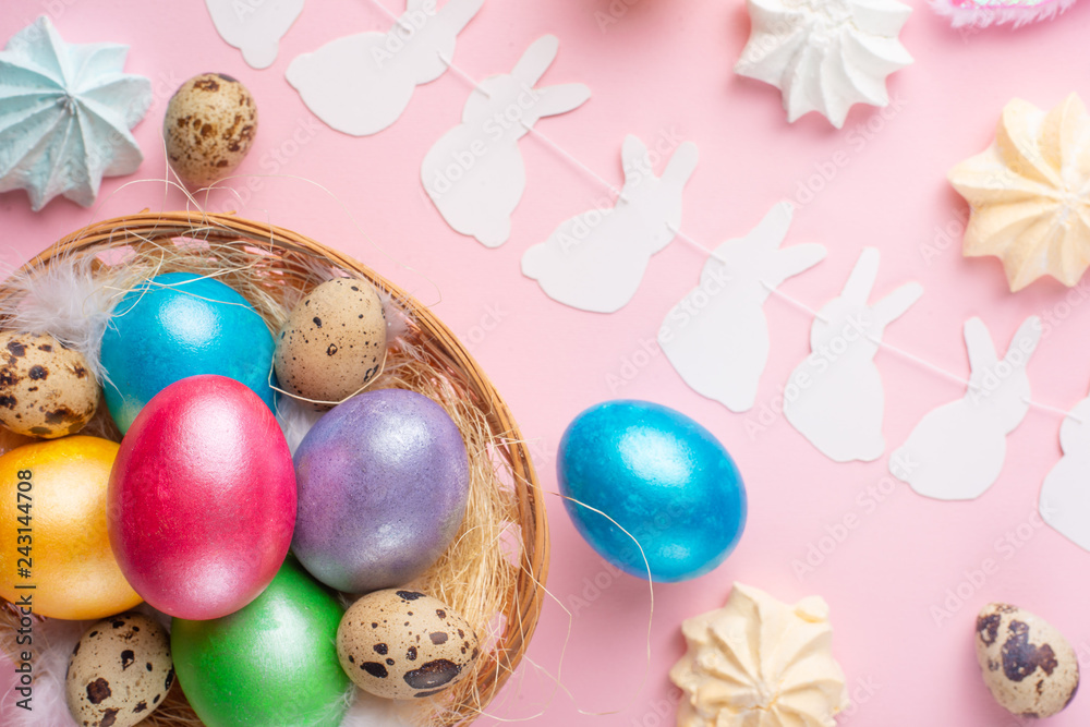 Fototapeta premium Easter holiday background. Easter eggs colored with rabbit ears on a pink background, horizontal composition. Greeting card concept