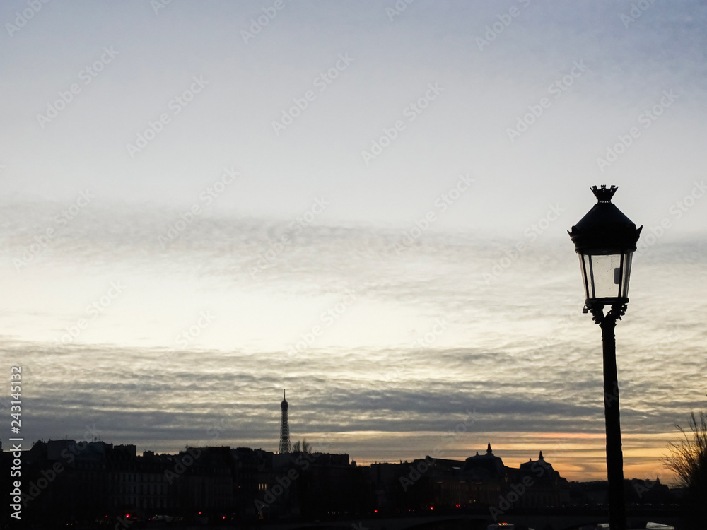A lamp post at sunset in the city of Paris