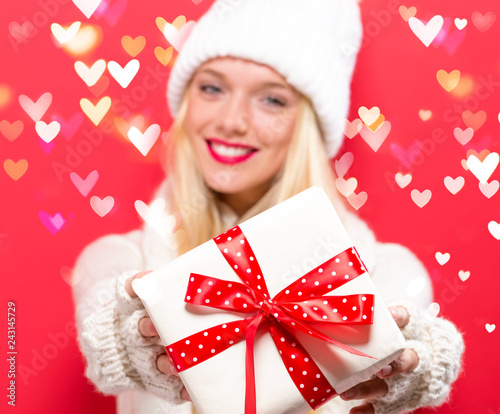 Young woman holding a gift box with heart lights photo