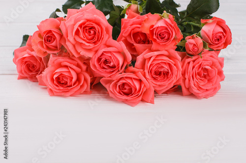 Bouquet of red blooming roses on white wooden table. Close up. Bunch of bright flowers.
