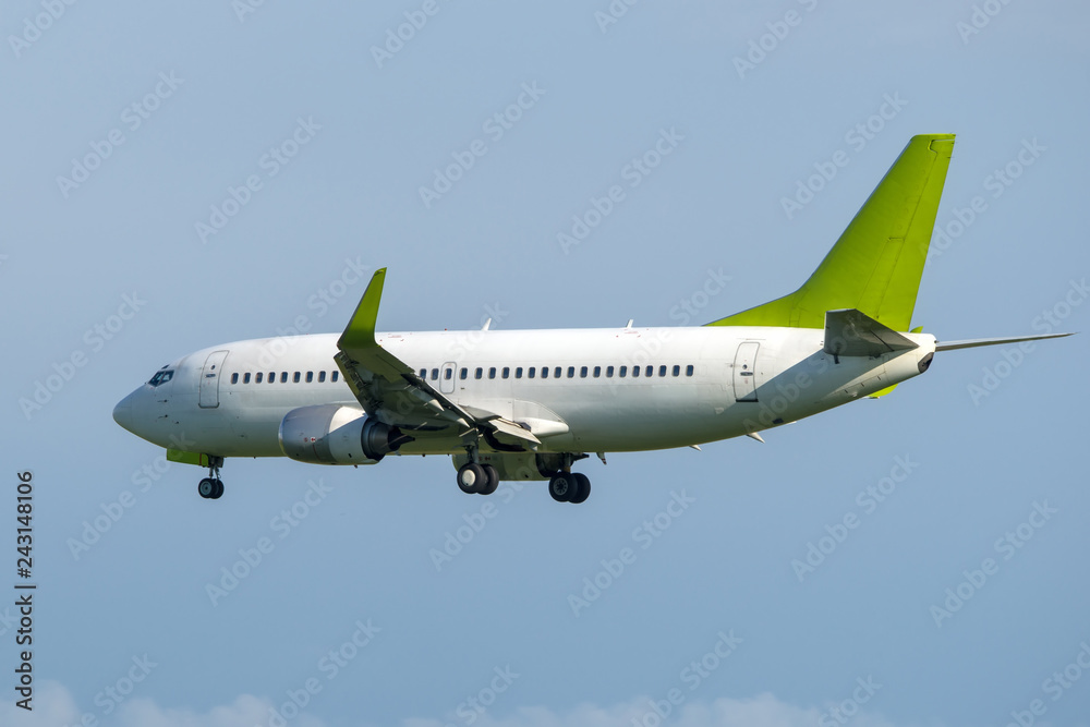 White passenger airplane with green tail landing. White passenger airplane with green tail landing.