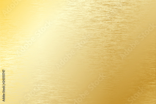 Brushed gold metal plate with light reflections.