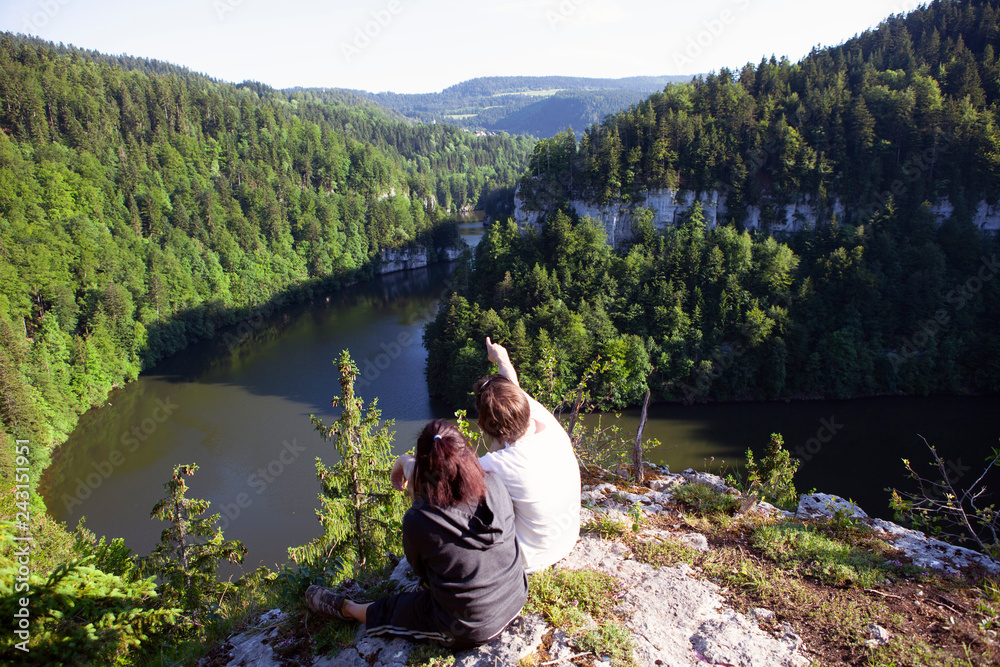 Couple enjoying breathtaking landscape from top of a cliff