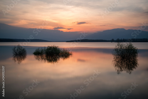 Beautiful landscape with fiery sunset over a lake . View from the coast - Image