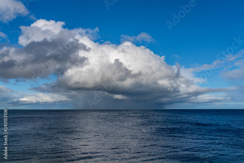 Fototapeta Naklejka Na Ścianę i Meble -  Rainclouds and a rainbow over the North Sea in Benthall, Northumberland, England, UK