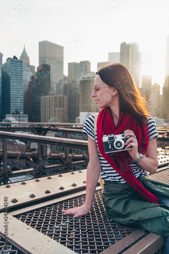 Smiling girl with a camera on Brooklyn Bridge