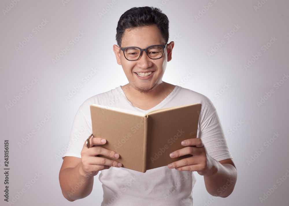 Happy Man Smiling While Reading Book Happy Man Smiling While Reading Book