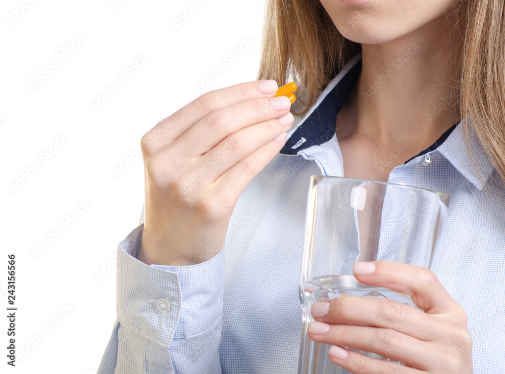 Orange capsule pill and glass of water medicine in woman hand on white background, pharmacy concept Orange capsule pill and glass of water medicine in woman hand on white background, pharmacy concept