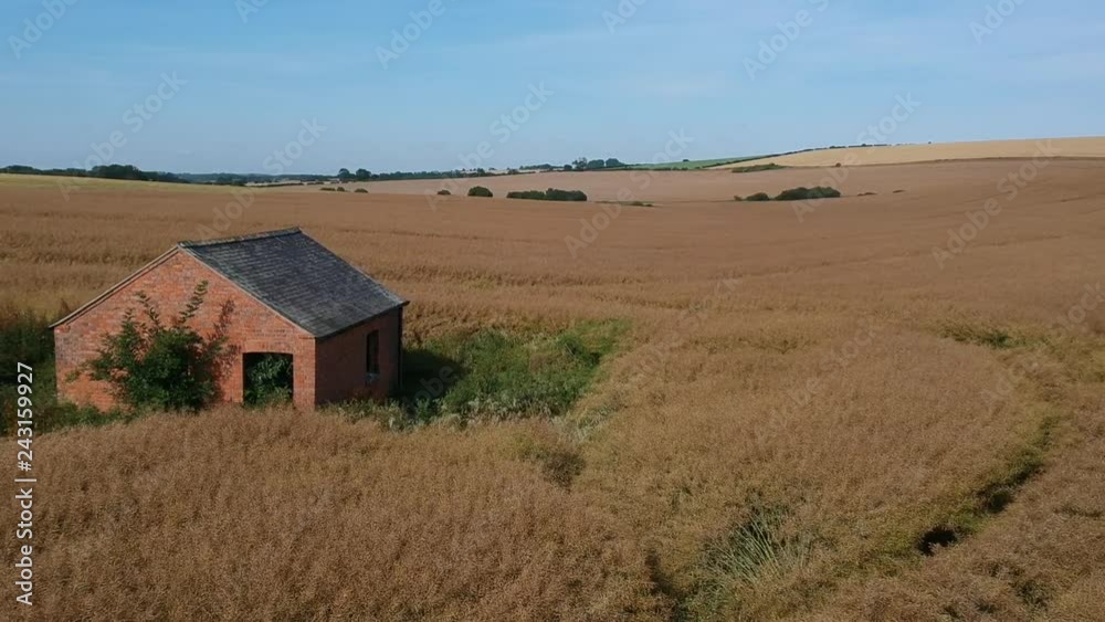 Hot summer dry farm crops abandoned building uk aerial by drone