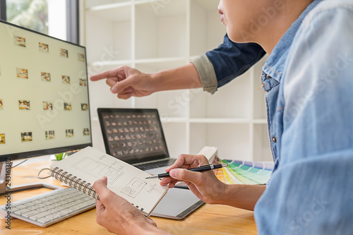 Graphic design with color swatches and tablet on a desk. Graphic designer drawing something on tablet at the office with work tools and accessories.