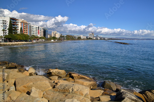 Krajobraz nadmorski w Limassol, Cypr,morze, kamisnisty, skalisty umocniony brze, w oddali aleja nadmorska wyadzana drzewami, wysokie budynki