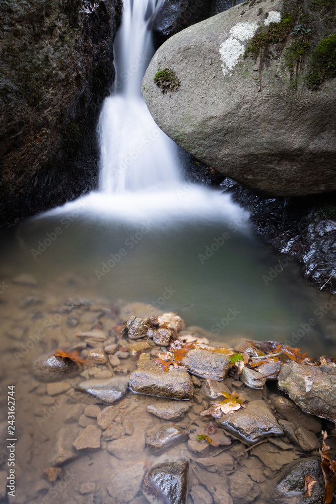 Fototapeta premium beautiful forest waterfall creek in long exposure in fall scenery