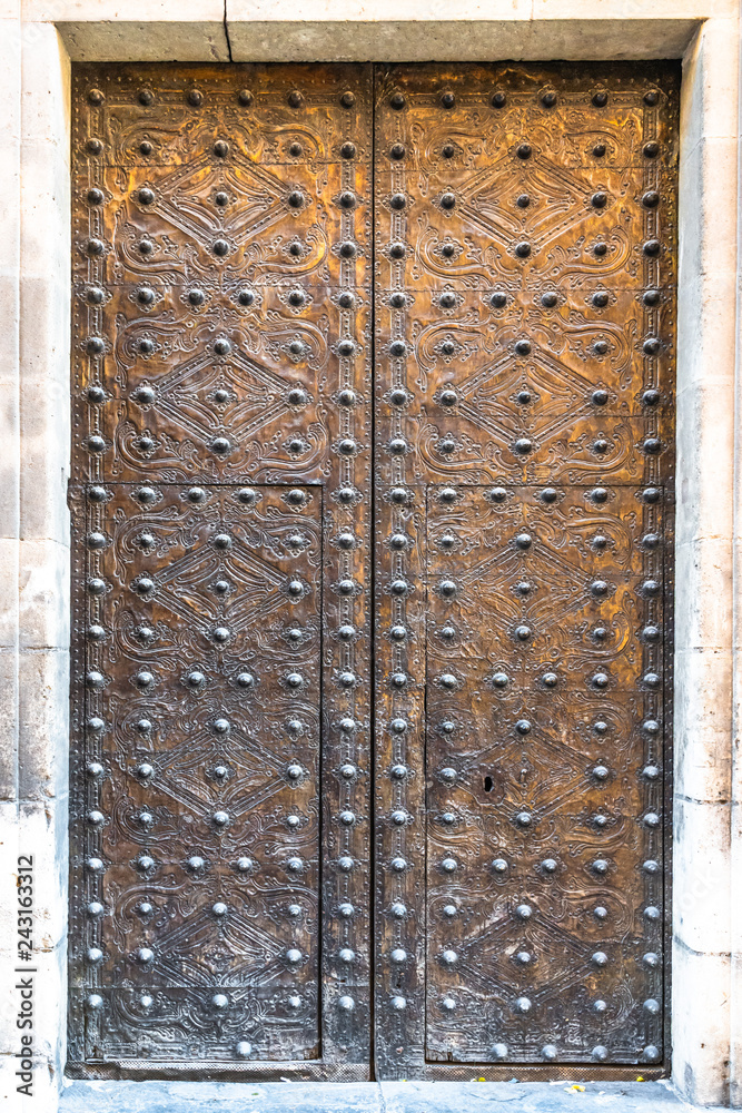 Medieval doors.  Spanish traditional ornament on wooden gates. Old wooden gate texture. Strong fortress, Spain.