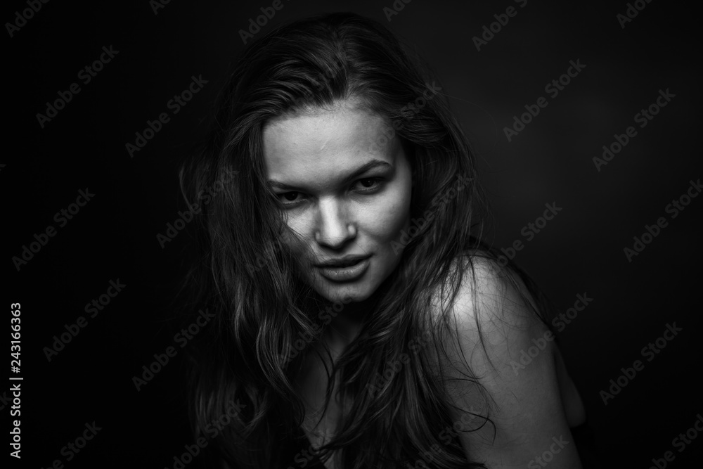 Dramatic black and white portrait of a beautiful girl on a dark background Dramatic black and white portrait of a beautiful girl on a dark background