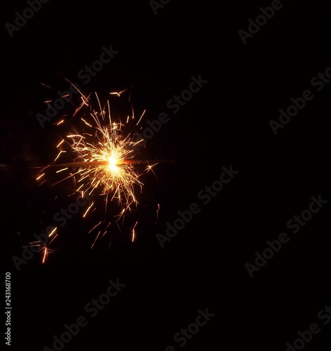 Sparklers in the dark. A sheaf of bright sparks and fire.