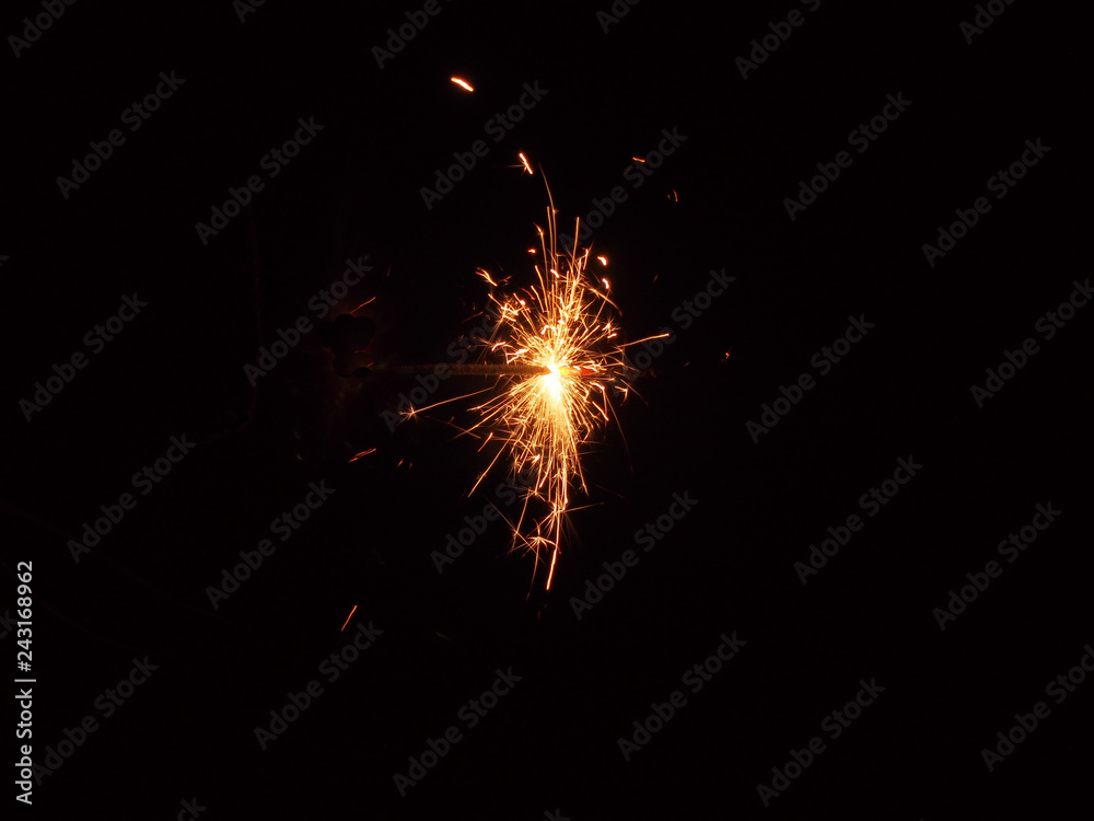 Sparklers in the dark. A sheaf of bright sparks and fire.